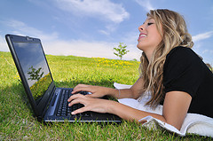 Young lady working outside on her laptop
